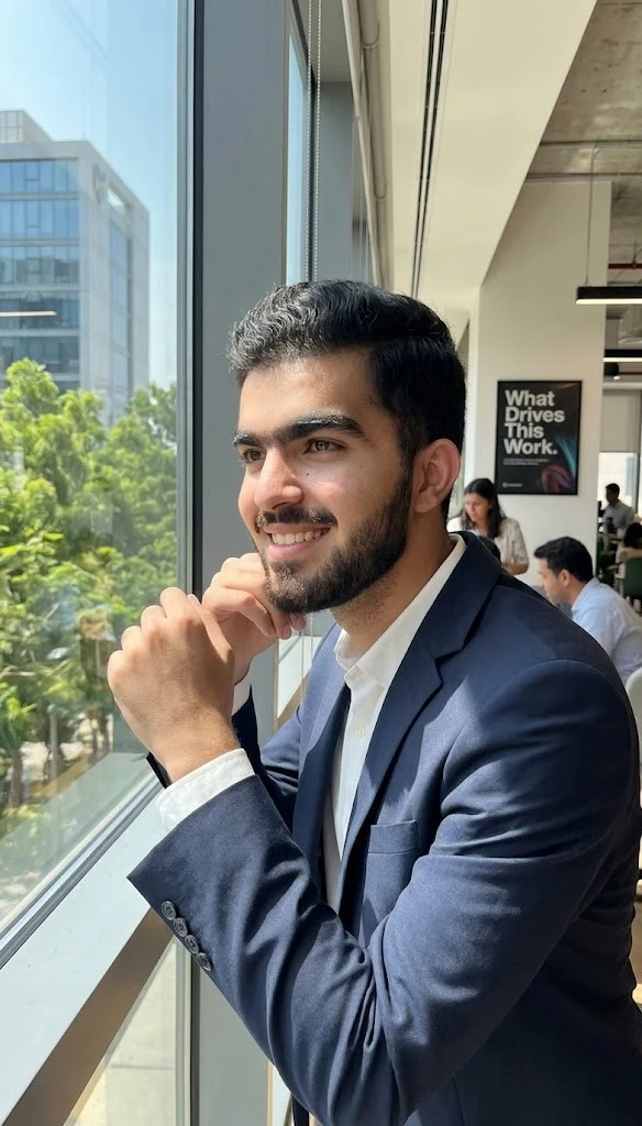 Hussain Jatoi smiling in formal suit near office window